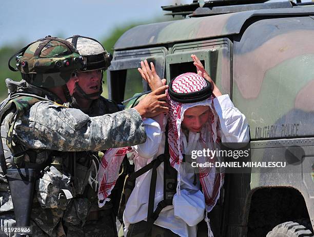 Soldiers arrest a mock suspect wearing arab outfits on July 14, 2008 at Babadag training facility in the county of Tulcea, at the Joint Task...