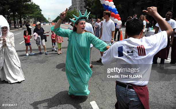 Woman dressed as the Statue of Liberty dances with a race participant during The Brasserie Les Halles 34th Annual Waiter and Waitress Race to...