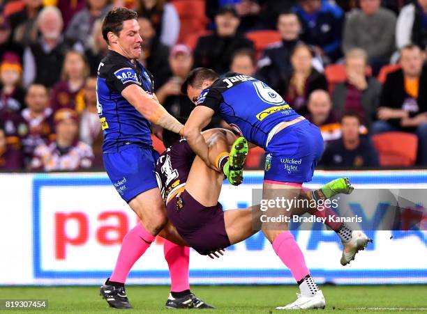 Kodi Nikorima of the Broncos is picked up in the tackle by Josh Jackson and Josh Reynolds of the Bulldogs during the round 20 NRL match between the...