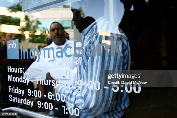 Security guard opens the door for 70-year-old Charles Tengeri who was only able to withdraw about two-thirds of his life savings and retirement...