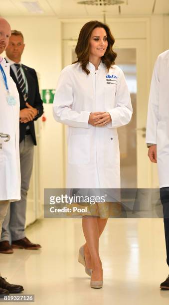 Catherine, Duchess of Cambridge dons a white lab coat during her visit to the German Cancer Research Institute on day 2 of their official visit to...