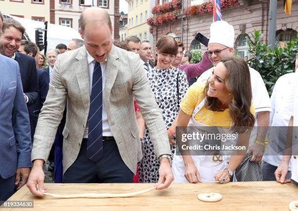 Prince William, Duke of Cambridge and Catherine, Duchess of Cambridge attempt to make pretzels during a tour of a traditional German market in the...