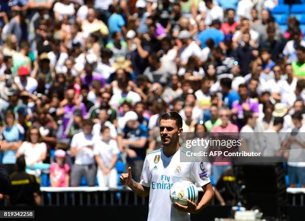 Spanish midfielder Dani Ceballos gives the thumbs up as he poses on the pitch during his presentation as new football player of the Real Madrid CF at...