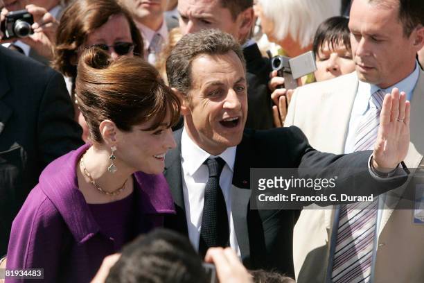 French President Nicolas Sarkozy and wife Carla Bruni-Sarkozy wave to the crowd as they leave the ceremony for Bastille Day, on July 14, 2008 in...