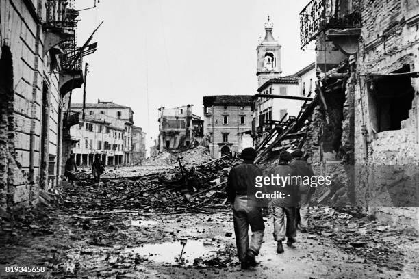 Picture released in 1944 of troops crossing the mids of debris of the rubble-strewn streets in Rimini, Italy, during the 2nd World war.