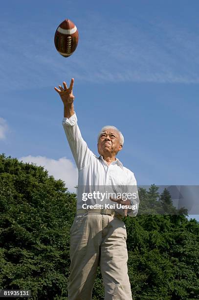 a senior man with football in the air - arremessar imagens e fotografias de stock