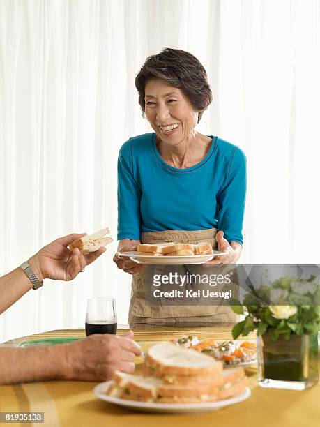 a senior woman with food, smiling - japanese fat man bildbanksfoton och bilder