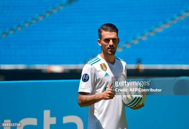 Spanish midfielder Dani Ceballos gives a thumb up as he poses on the pitch during his presentation as new football player of the Real Madrid CF at...