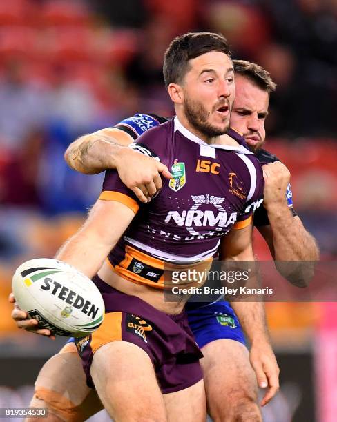 Ben Hunt of the Broncos offloads as he is pressured by the defence of Josh Reynolds of the Bulldogs during the round 20 NRL match between the...