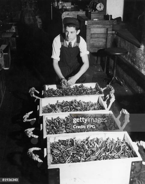 Worker at a Canadian ammunition factory with four boxes of bullets during World War II, circa 1943.