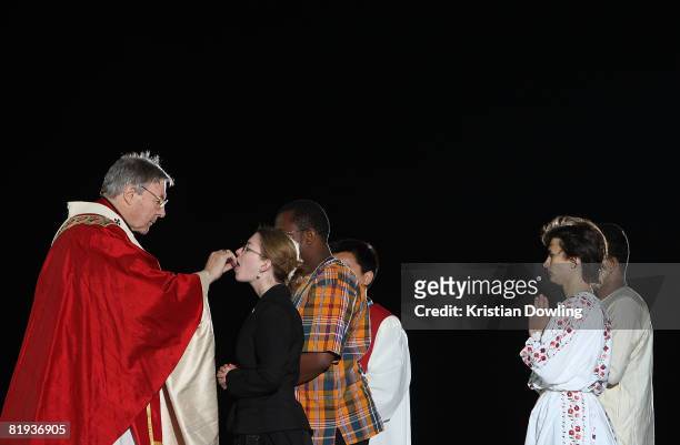 Archbishop of Sydney Cardinal George Pell AC performs the Eucharist on stage at the Opening Mass formally celebrating the start of World Youth Day...