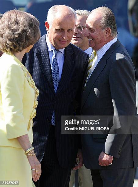 Spain's King Juan Carlos chats with Thierry Peugeot , Chairman of the PSA Supervisory Board, next to Queen Sofia during their visit at the PSA...