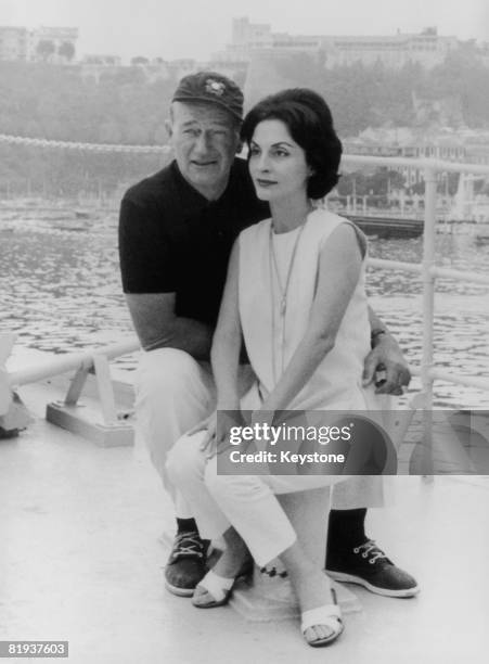 American actor John Wayne with his wife Pilar on board their yacht 'The Wild Goose' at Monte Carlo, following a transatlantic crossing, 26th August...