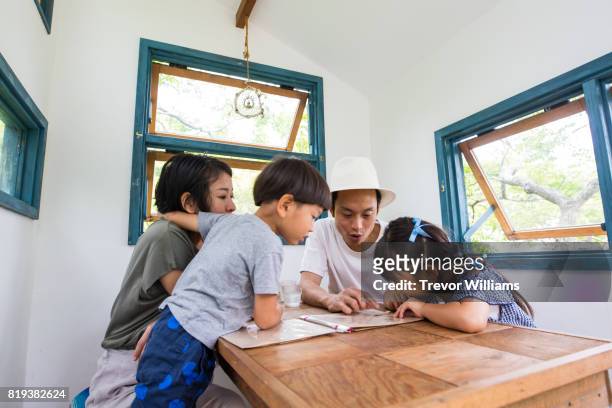 young family in a cafe looking at a menu and deciding - open day 4 stock pictures, royalty-free photos & images