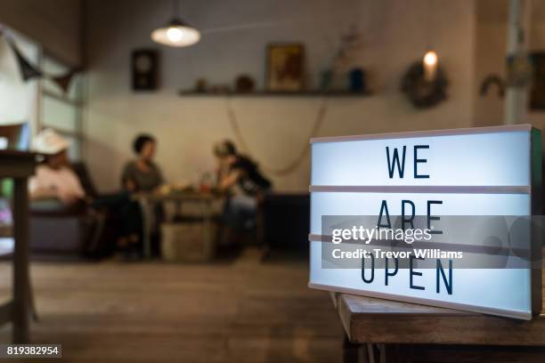 a sign reads "we are open" in front of a cafe - open sign stock pictures, royalty-free photos & images