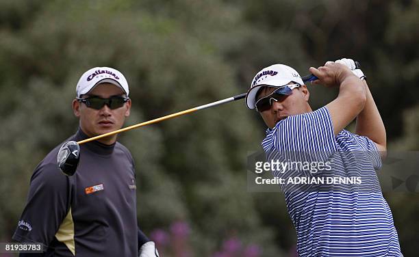 Lam Chih-Bing of Singapore drives off the 2nd hole as Angelo Que of Phillipines looks on during the second practice day at the British Open golf...