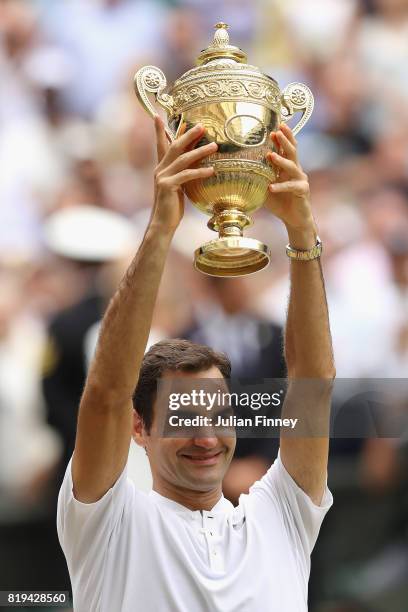 Roger Federer of Switzerland lifts the trophy as he celebrates victory after the Gentlemen's Singles final against Marin Cilic of Croatia on day...