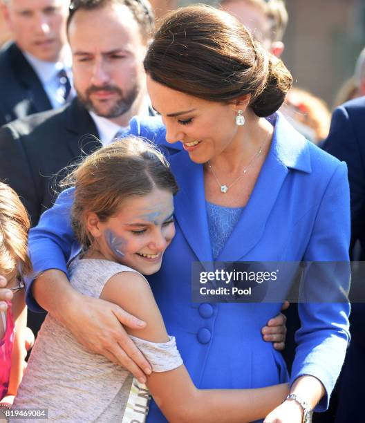 Catherine, Duchess of Cambridge hugs a child as she visits Strassenkinder, a charity which supports young people from disadvantaged backgrounds...