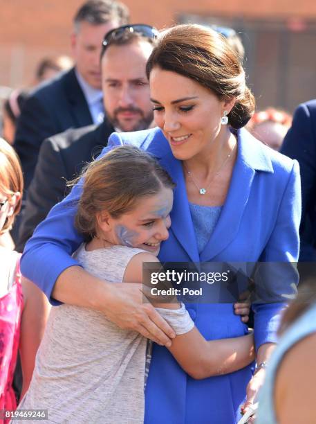 Catherine, Duchess of Cambridge hugs a child as she visits Strassenkinder, a charity which supports young people from disadvantaged backgrounds...