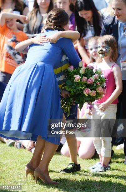 Catherine, Duchess of Cambridge hugs a child as she visits Strassenkinder, a charity which supports young people from disadvantaged backgrounds...