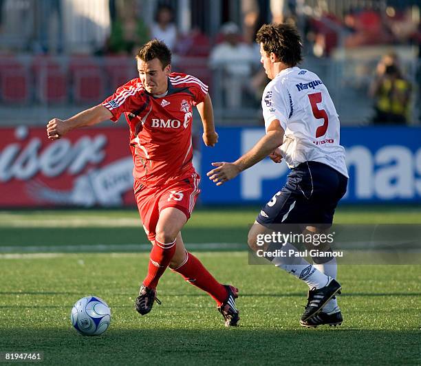 Midfielder Tyler Rosenlund of Toronto FC runs from midfielder Lucas Pusineri of Independiente during their match on July 15, 2008 at BMO Field in...