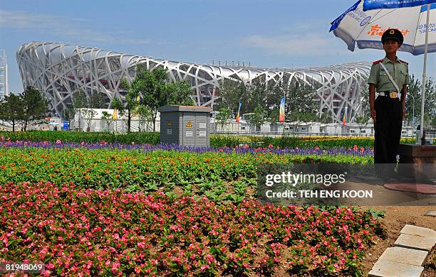 Chinese paramilitary policeman stands guard next the National Stadium "Bird's Nest" in Beijing on July 16, 2008. Chinese police have broken up 12...
