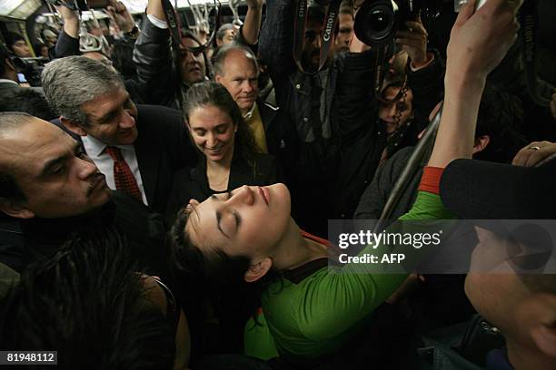 Chilean pole dancer Monserrat Morilles attempts to dance while surrounded by Santiago's subway security personnel on July 15, 2008 in Santiago....