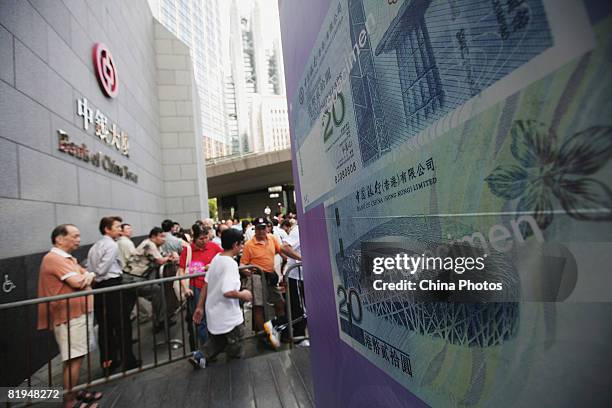 Residents line up outside a branch of the Bank Of China to buy the special-edition of 20 Hong Kong dollar and 20 pataca Olympic banknotes on July 16,...
