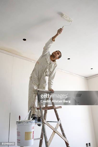 painter painting ceiling of office - decorating stock pictures, royalty-free photos & images