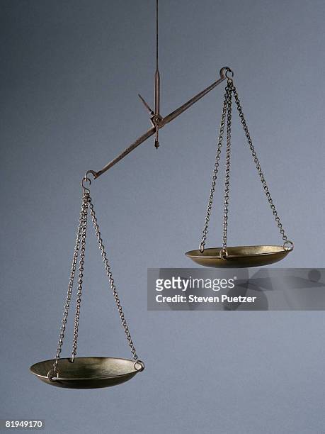 imbalanced weight scale against gray background - scales imagens e fotografias de stock