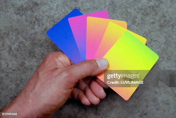 hand holding coloured cards - hand of cards stock-fotos und bilder