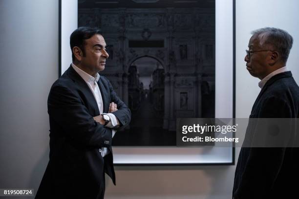 Carlos Ghosn, chairman of Renault SAS, Nissan Motor Co., and Mitsubishi Motors Corp., left, speaks with Japanese photographer Hiroshi Sugimoto at his...