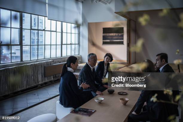 Carlos Ghosn, chairman of Renault SAS, Nissan Motor Co., and Mitsubishi Motors Corp., right, sits with Japanese photographer Hiroshi Sugimoto, center...