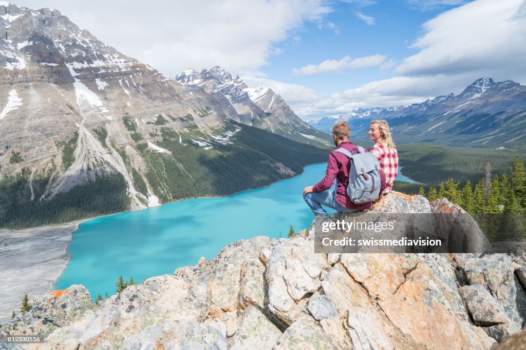 Couple of hikers overlooking mountain lake