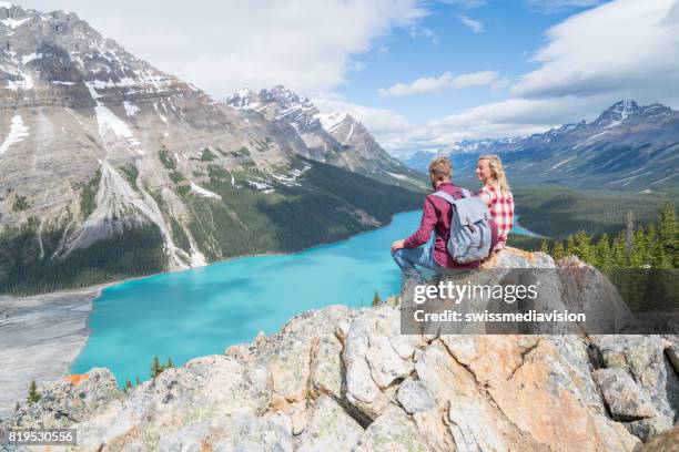 couple of hikers overlooking mountain lake - montanhas rochosas canadianas imagens e fotografias de stock