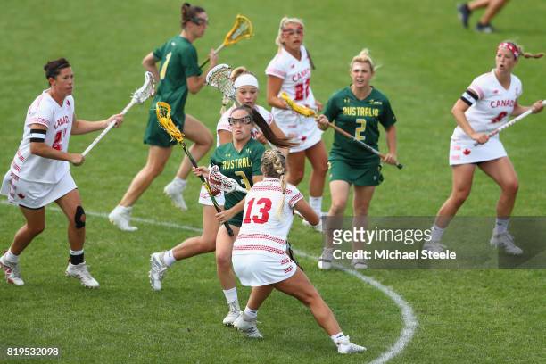 Rebecca Lane of Australia cuts between Kay Morissette and Lydia Sutton of Canada during the semi-final match between Australia and Canada during the...