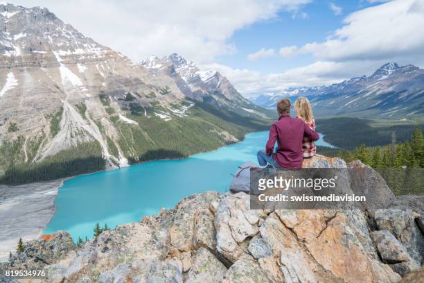 couple of hikers overlooking mountain lake - peyto lake stock pictures, royalty-free photos & images