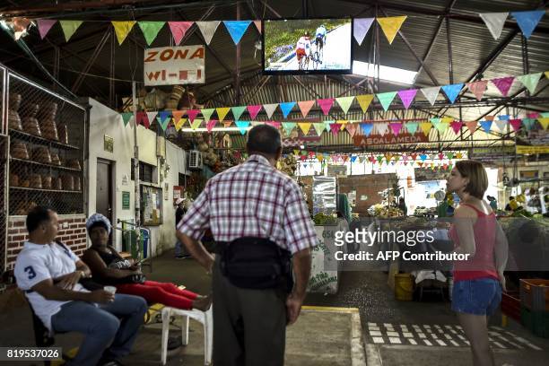 People look on a large screen the broadcasting of the 104th edition of the Tour de France cycling race on July 20, 2017 in Cali, Colombia. / AFP...