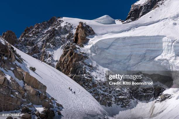 alpinist climbing on mont blanc massif, france - aiguille du midi stock-fotos und bilder
