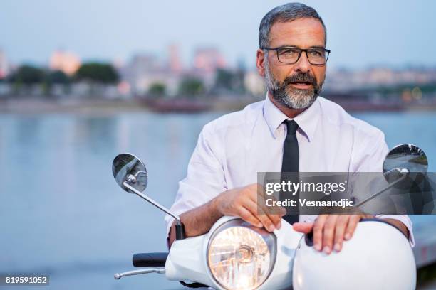 hombre de negocios maduro en vespa - montar un vehículo fotografías e imágenes de stock