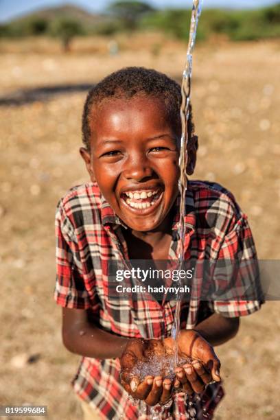 african young boy drinking fresh water on savanna, east africa - kenya children stock pictures, royalty-free photos & images