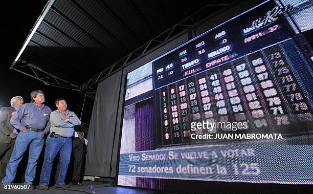 Farming leaders watch a giant screen showing a board with the results of the Senate vote on a controversial grain tax bill that ended in a virtual...