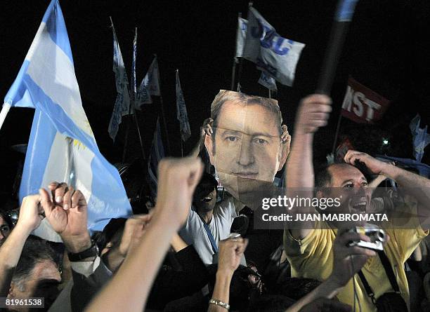 Farmers and supportes celebrate while holding a portrait of Argentine Vice President Julio Cobos after the Argentine Senate rejected a controversial...