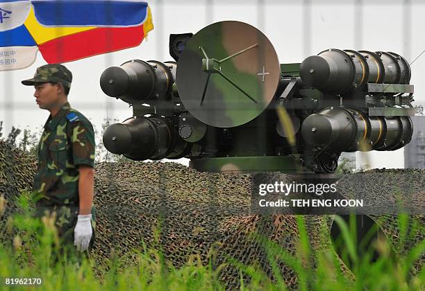 Chinese soldier stands guard in front of surface-to-air missile launchers at a military administrative area near the Olympic Green on July 17 22 days...