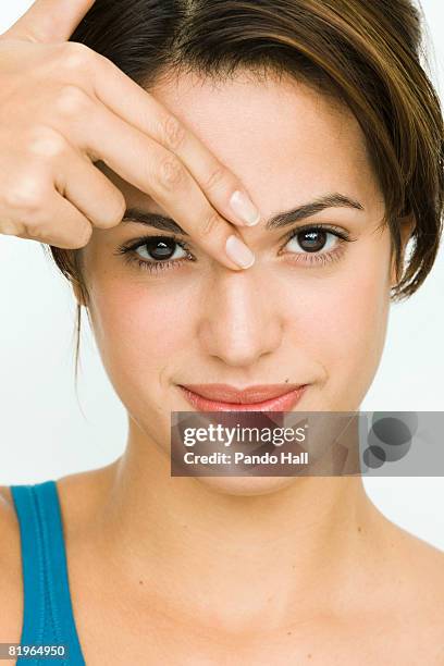young woman fingers on forehead, portrait - pressure point stock pictures, royalty-free photos & images