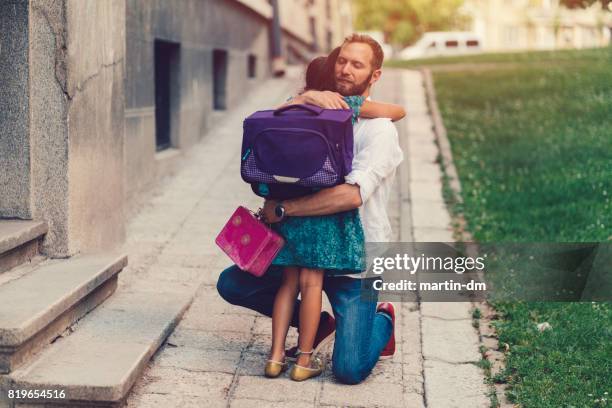 petite fille étreindre son père avant d’aller à l’école - enfant cartable photos et images de collection