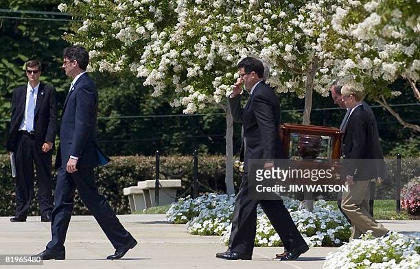 An urn carrying the ashes of former White House spokesman Tony Snow is ushered from the Basilica of the National Shrine of the Immaculate Conception...
