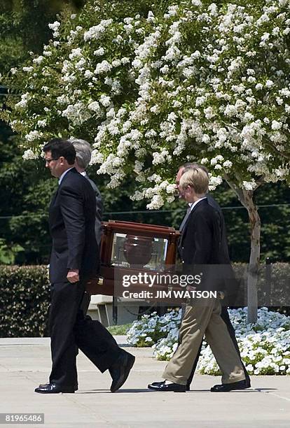 An urn carrying the ashes of former White House spokesman Tony Snow is ushered from the Basilica of the National Shrine of the Immaculate Conception...