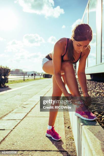 photo of a woman running while sun is setting - running in the sun stock-fotos und bilder