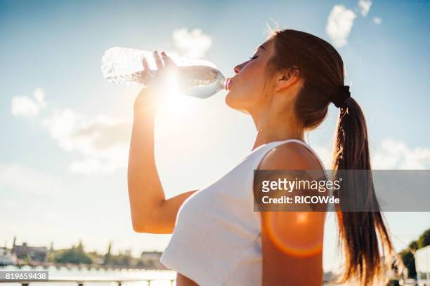 photo of a woman running while sun is setting - garrafa de água garrafa imagens e fotografias de stock